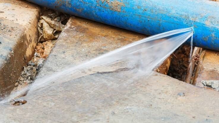 Blue pipe leaking water onto concrete surface